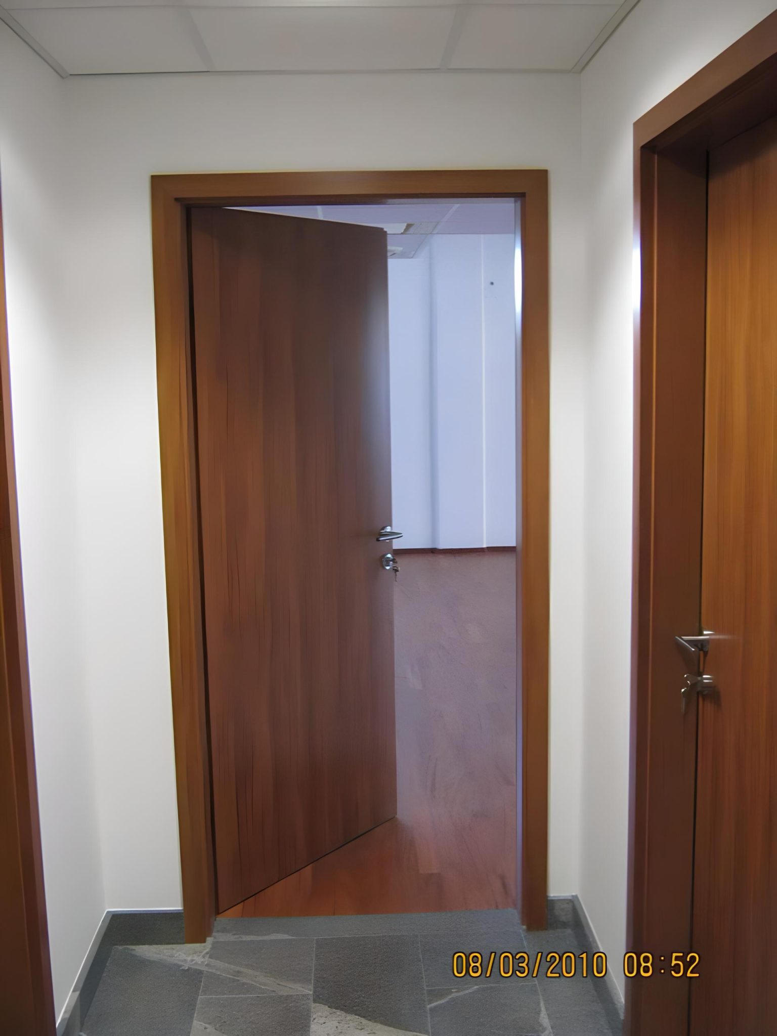 Notranja vrata v temnejši leseni izvedbi v hodniku poslovnega objekta Advansys.