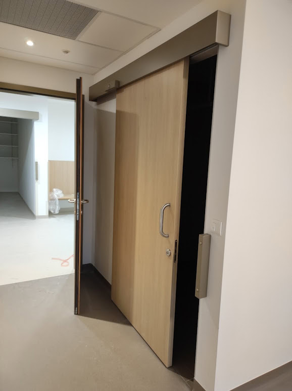 Protipožarna drsna vrata s poteznim ročajem v hodniku doma starejših.