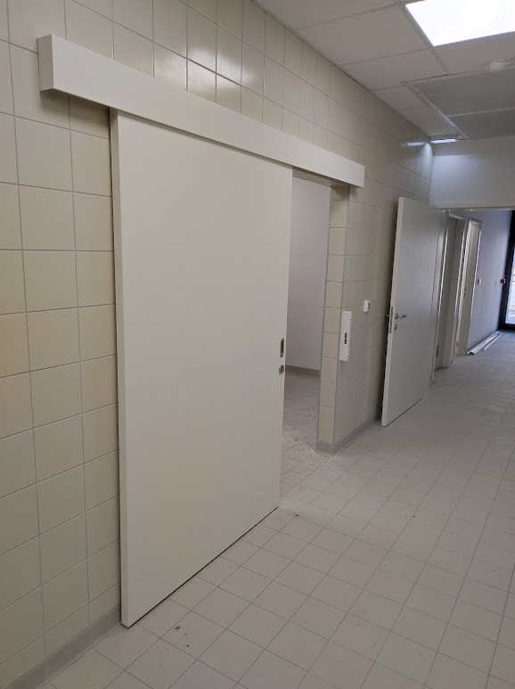 Bela protipožarna vrata v sanitarnem prostoru DSO Ajdovščina.