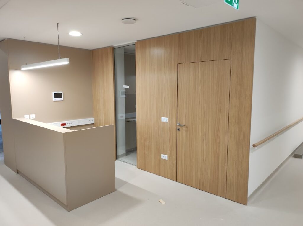 Lesena protipožarna vrata v Domu starejših občanov Ajdovščina ob recepciji oddelka.